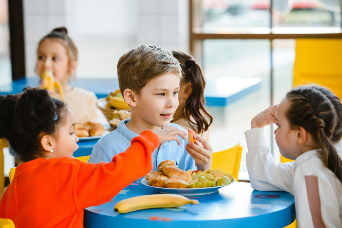 Trois élèves du primaire prennent une collation.